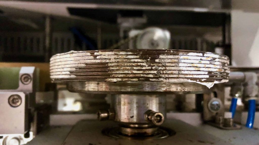 Flow wrapper fin wheels contaminated with packaging material and product