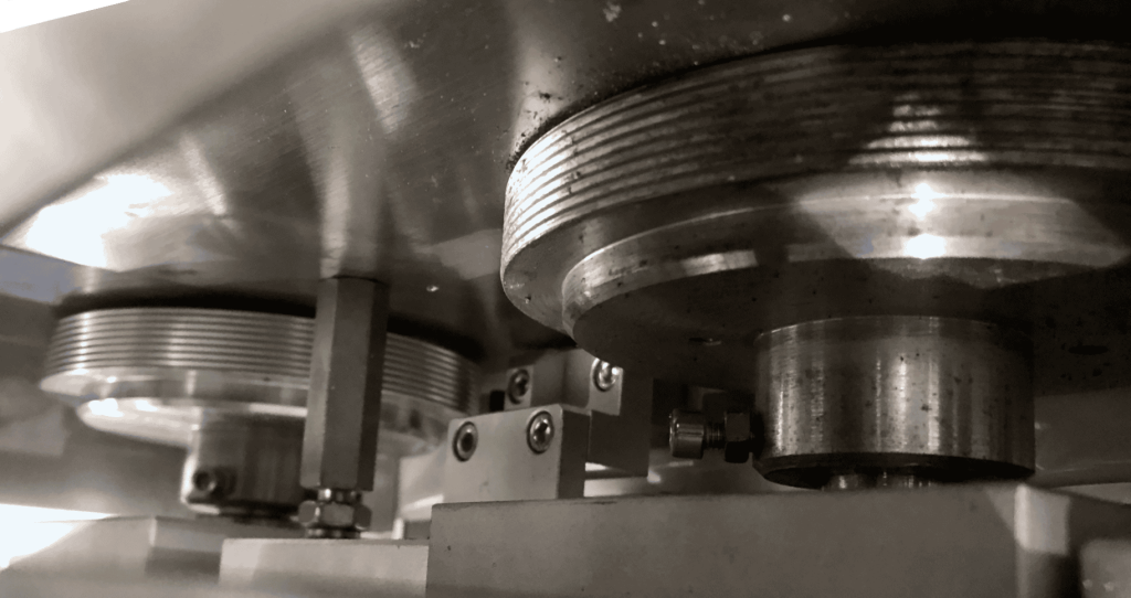 Fin wheels beneath cover plate on flow wrapper